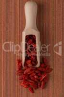 Wooden scoop with dry red goji berries