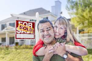 Couple in Front of Sold Real Estate Sign and House