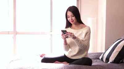 Relax For Asian Woman With Smartphone On Bed At Home