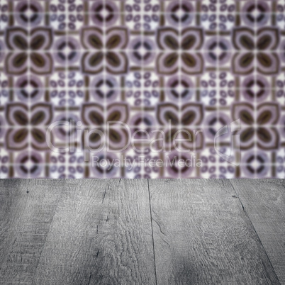 Wood table top and blur vintage ceramic tile pattern wall Wood table top and blur vintage ceramic tile pattern wall