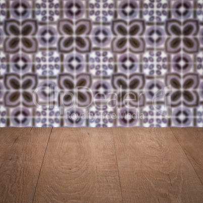 Wood table top and blur vintage ceramic tile pattern wall