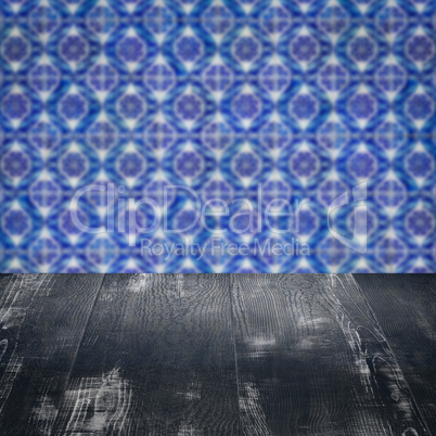 Wood table top and blur vintage ceramic tile pattern wall Wood table top and blur vintage ceramic tile pattern wall