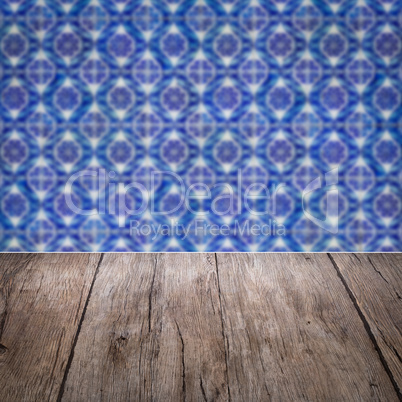 Wood table top and blur vintage ceramic tile pattern wall