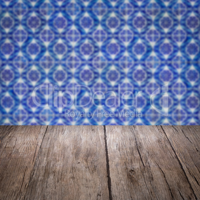 Wood table top and blur vintage ceramic tile pattern wall