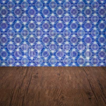 Wood table top and blur vintage ceramic tile pattern wall