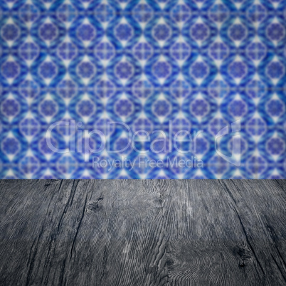 Wood table top and blur vintage ceramic tile pattern wall