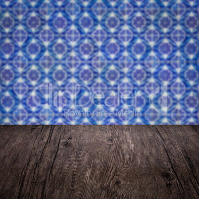 Wood table top and blur vintage ceramic tile pattern wall