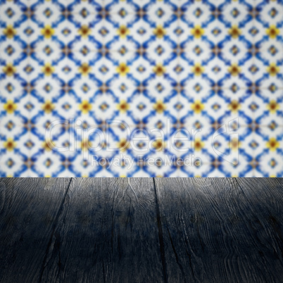 Wood table top and blur vintage ceramic tile pattern wall