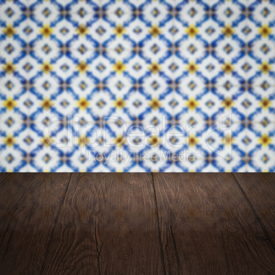 Wood table top and blur vintage ceramic tile pattern wall