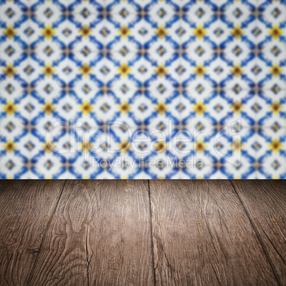 Wood table top and blur vintage ceramic tile pattern wall Wood table top and blur vintage ceramic tile pattern wall