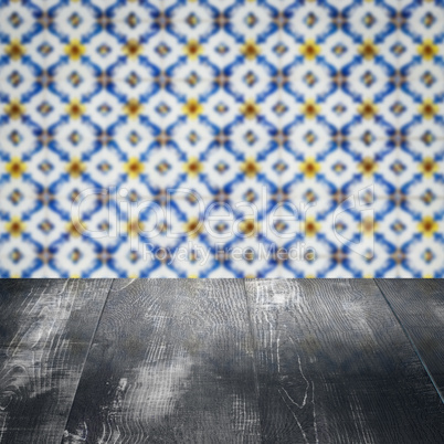 Wood table top and blur vintage ceramic tile pattern wall