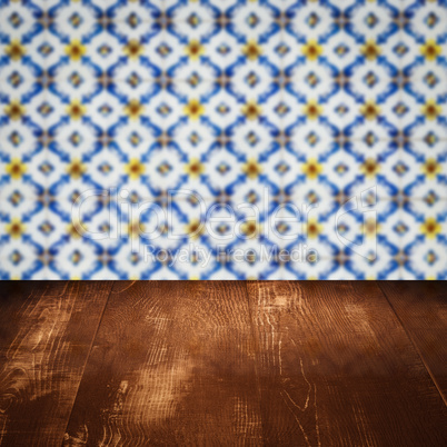Wood table top and blur vintage ceramic tile pattern wall Wood table top and blur vintage ceramic tile pattern wall