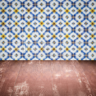 Wood table top and blur vintage ceramic tile pattern wall