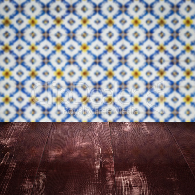 Wood table top and blur vintage ceramic tile pattern wall Wood table top and blur vintage ceramic tile pattern wall