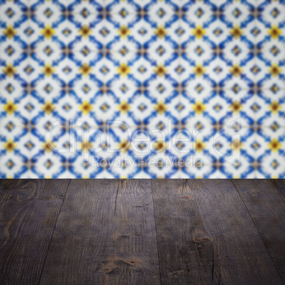 Wood table top and blur vintage ceramic tile pattern wall