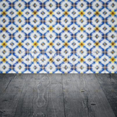 Wood table top and blur vintage ceramic tile pattern wall