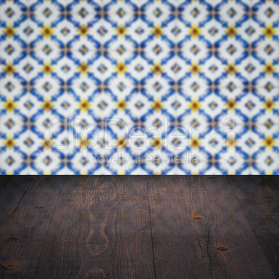 Wood table top and blur vintage ceramic tile pattern wall