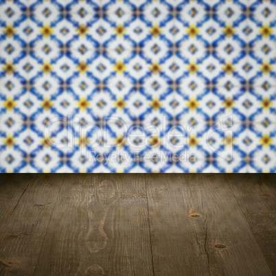 Wood table top and blur vintage ceramic tile pattern wall