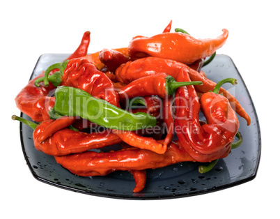 Red and green peppers on glass plate