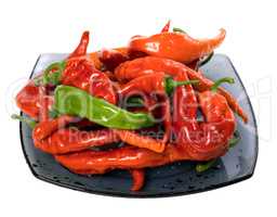 Red and green peppers on glass plate