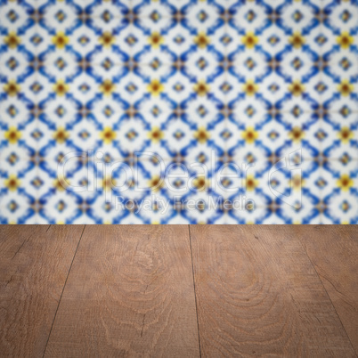 Wood table top and blur vintage ceramic tile pattern wall