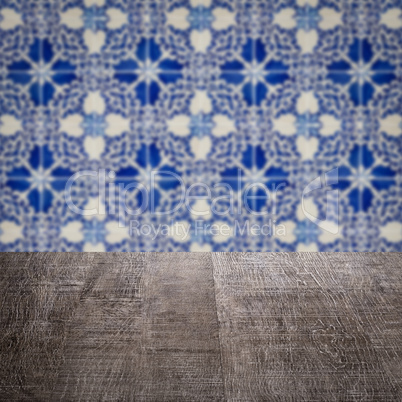 Wood table top and blur vintage ceramic tile pattern wall Wood table top and blur vintage ceramic tile pattern wall