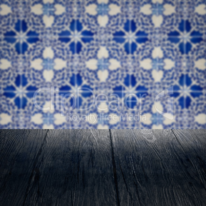 Wood table top and blur vintage ceramic tile pattern wall