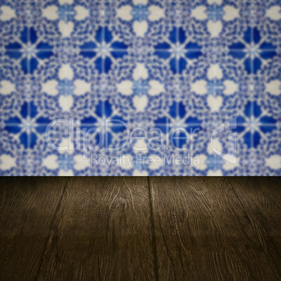 Wood table top and blur vintage ceramic tile pattern wall