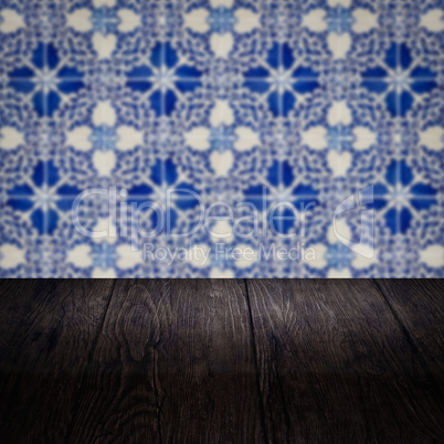 Wood table top and blur vintage ceramic tile pattern wall