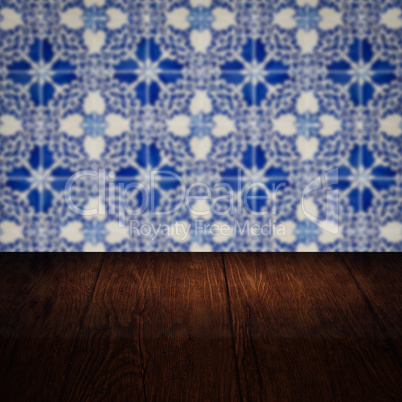 Wood table top and blur vintage ceramic tile pattern wall