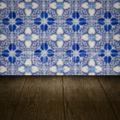 Wood table top and blur vintage ceramic tile pattern wall