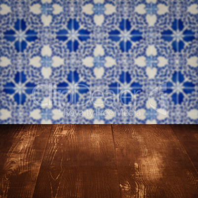 Wood table top and blur vintage ceramic tile pattern wall