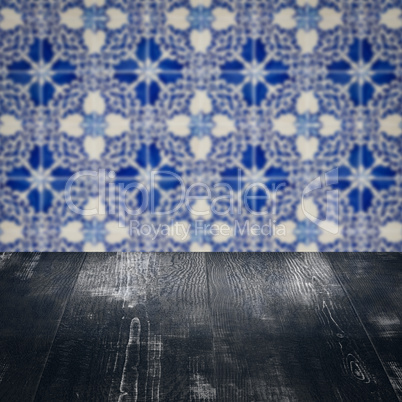 Wood table top and blur vintage ceramic tile pattern wall