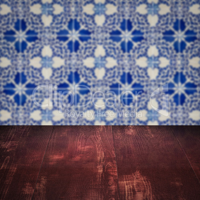 Wood table top and blur vintage ceramic tile pattern wall