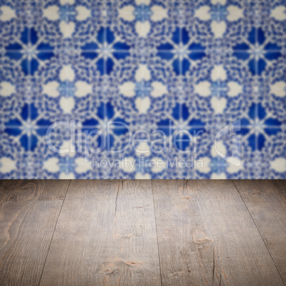Wood table top and blur vintage ceramic tile pattern wall Wood table top and blur vintage ceramic tile pattern wall