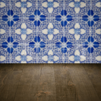 Wood table top and blur vintage ceramic tile pattern wall