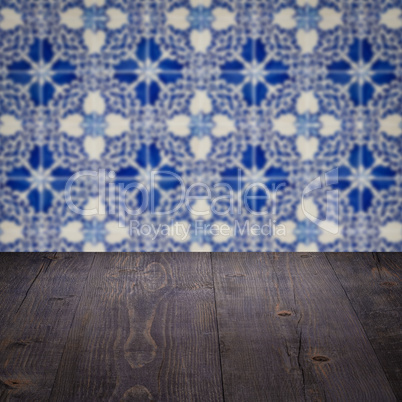 Wood table top and blur vintage ceramic tile pattern wall