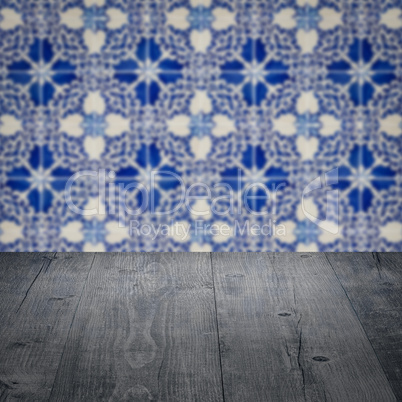 Wood table top and blur vintage ceramic tile pattern wall