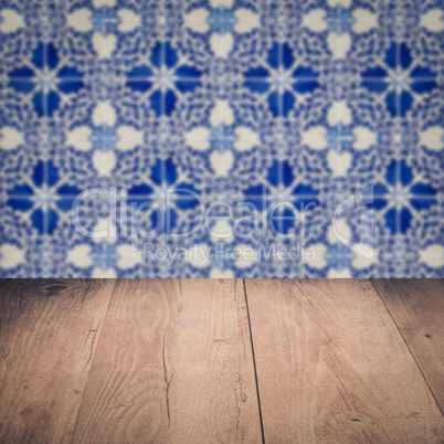 Wood table top and blur vintage ceramic tile pattern wall