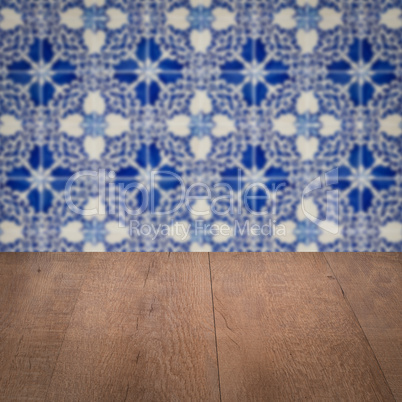 Wood table top and blur vintage ceramic tile pattern wall