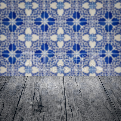 Wood table top and blur vintage ceramic tile pattern wall Wood table top and blur vintage ceramic tile pattern wall