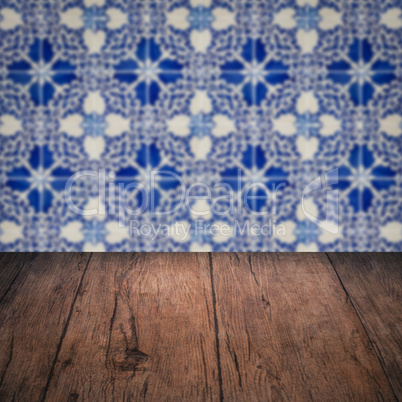 Wood table top and blur vintage ceramic tile pattern wall