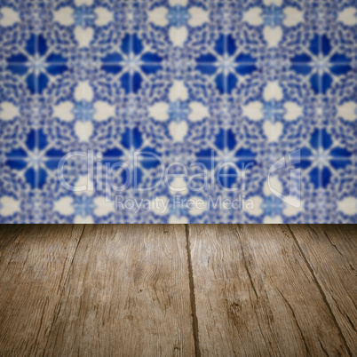 Wood table top and blur vintage ceramic tile pattern wall