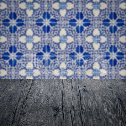 Wood table top and blur vintage ceramic tile pattern wall Wood table top and blur vintage ceramic tile pattern wall