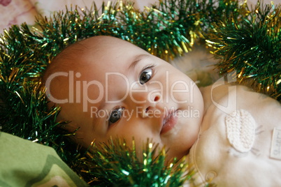 Very cute little baby lying on the bed, smiles and fun