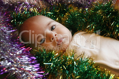 little cute girl lying in bed with a Christmas garland