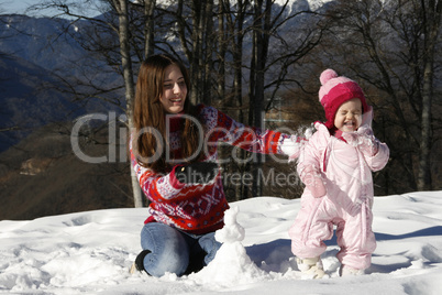 Mother and daughter playing in the snow