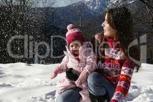 Mother and daughter playing in the snow