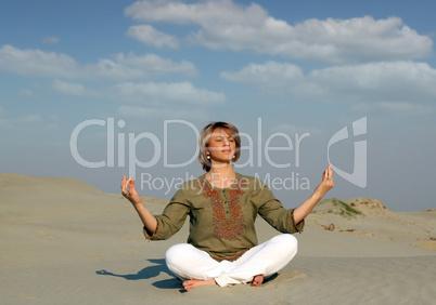 beautiful woman meditating in desert