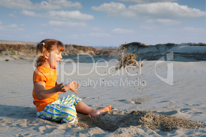 happy little girl playing in sand